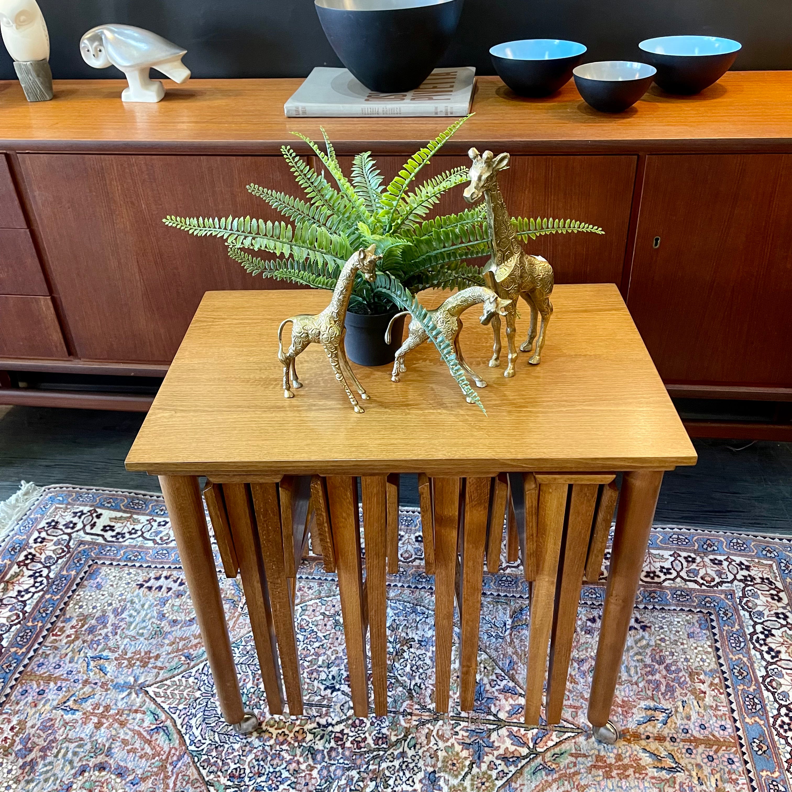 Mid Century Poul Hundevad Nesting Tables, a timeless and versatile addition to your living space. This exquisite set consists of five tables, with four of them ingeniously designed as drop-leaf tables that effortlessly slide beneath the main table, offering both functionality and aesthetic appeal.