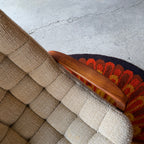 Close-up of sculpted teak armrest on a vintage Huber scoop chair, showing smooth curves and rich natural wood grain.