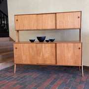 Two-tier Teak Danish Sideboard Credenza. The upper tier hosts a cabinet with sliding doors for storage. Below, sliding doors open to compartments with adjustable shelves, and drawers for small items. Solid sculptural teak legs tie the piece together. | Mr. Mansfield Vintage.