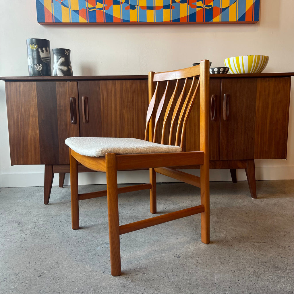 Side view of RS Associates solid teak dining chair with neutral upholstery
