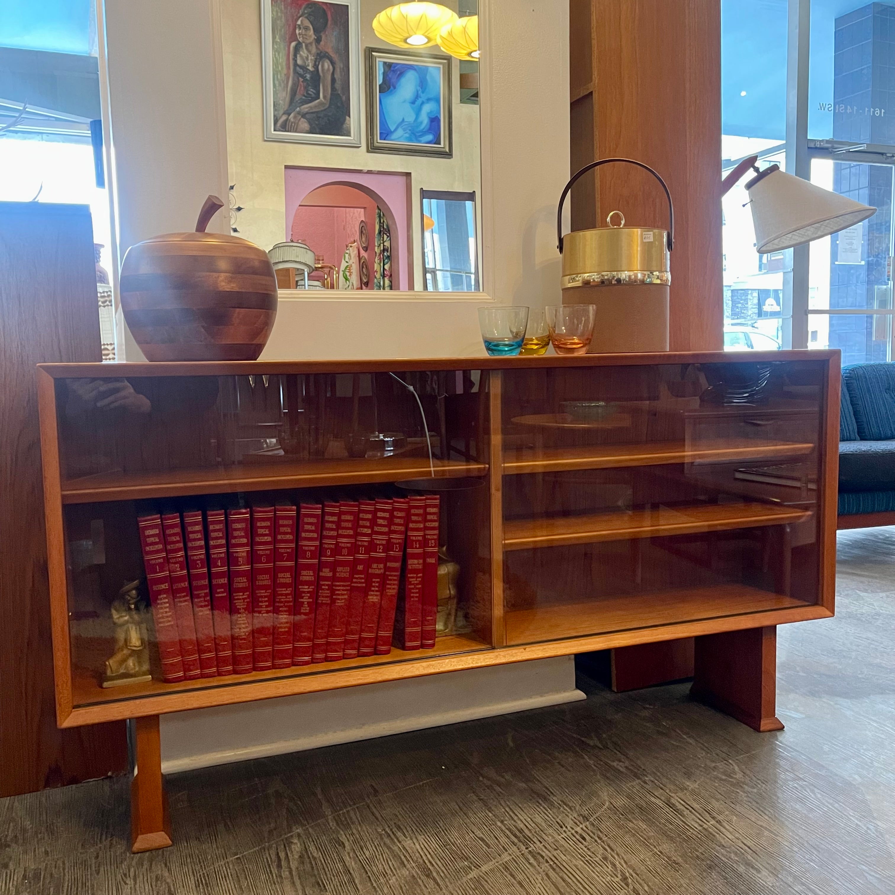This 1960s Danish Mid Century Hutch exudes timeless elegance with its sleek design and functional features. It has three adjustable shelves, perfect for showcasing your most cherished items. The two sliding glass doors add a touch of sophistication while allowing easy access to your display pieces.