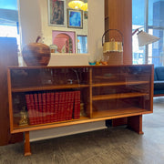 This 1960s Danish Mid Century Hutch exudes timeless elegance with its sleek design and functional features. It has three adjustable shelves, perfect for showcasing your most cherished items. The two sliding glass doors add a touch of sophistication while allowing easy access to your display pieces.
