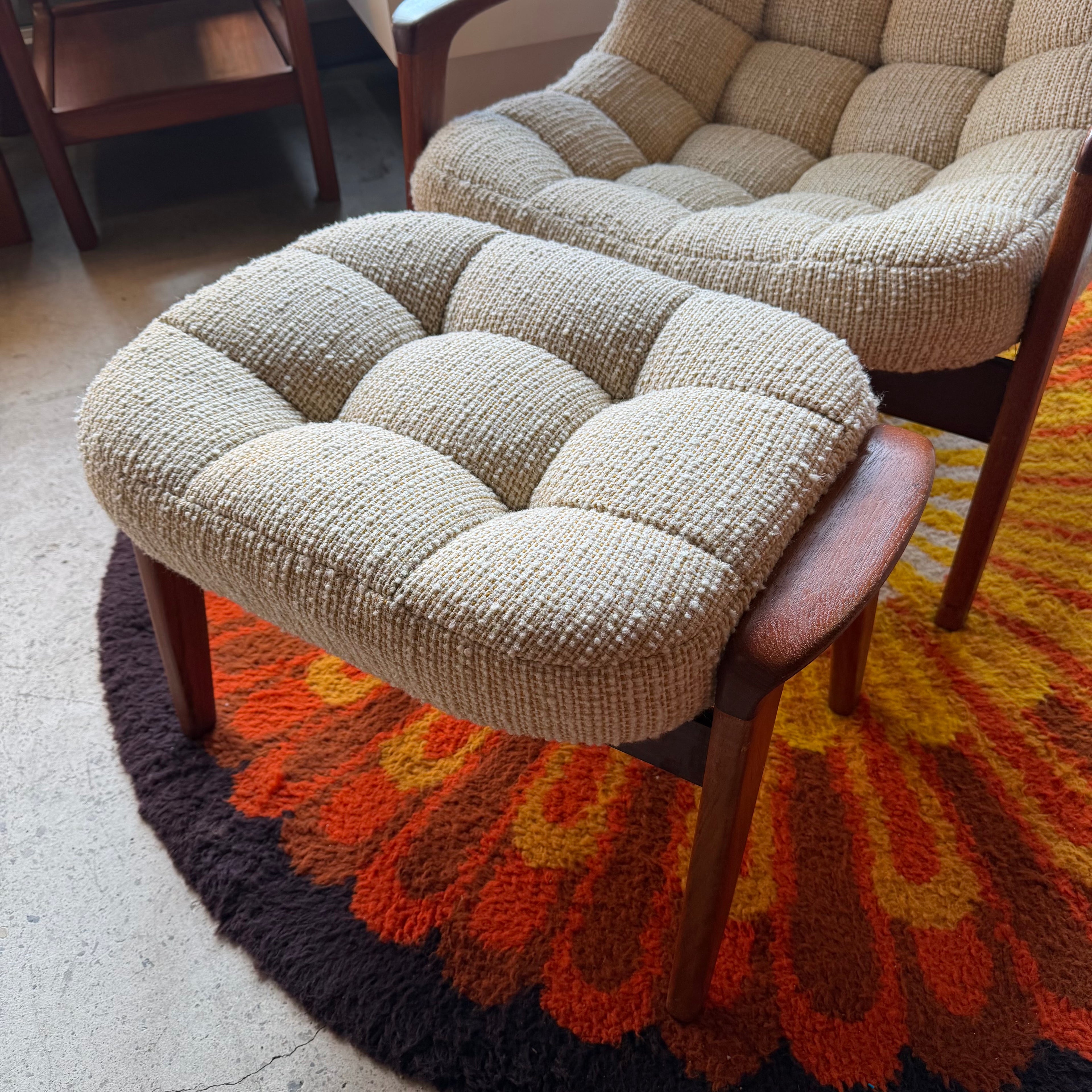 Huber scoop chair ottoman in beige upholstery with teak base, a curved vintage modern silhouette and matching sculptural design.