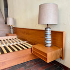 The centerpiece of any bedroom, this platform bed features a clean, minimalist design with a low-profile frame that offers a sense of spaciousness. The headboard, showcasing the natural beauty of teak, adds a touch of organic allure to the overall aesthetic. Its seamless integration with the floating nightstands on both sides creates a cohesive and balanced look.