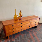 R.S. Associates teak nine drawer dresser with black metal pulls and mid-century credenza profile