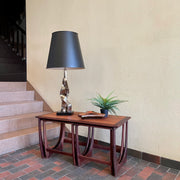 Teak G Plan nesting tables. Chrome Lamp with black shade, fern plant and an ashtray sits on top.There are 2 tables that pull out from under the main tablw. 