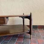 Close-up of brass-capped legs on vintage walnut and mahogany coffee table