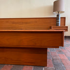 The centerpiece of any bedroom, this platform bed features a clean, minimalist design with a low-profile frame that offers a sense of spaciousness. The headboard, showcasing the natural beauty of teak, adds a touch of organic allure to the overall aesthetic. Its seamless integration with the floating nightstands on both sides creates a cohesive and balanced look.