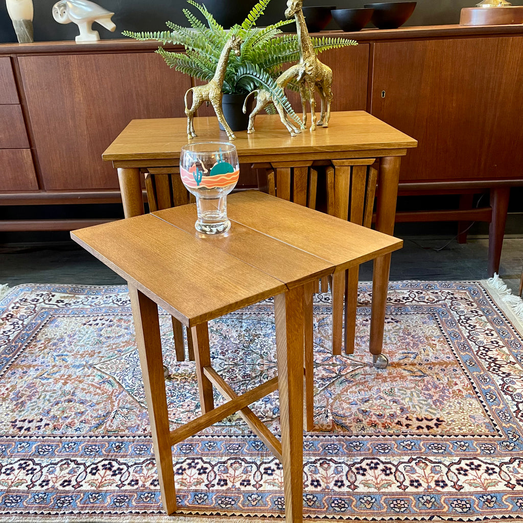 Mid Century Poul Hundevad Nesting Tables, a timeless and versatile addition to your living space. This exquisite set consists of five tables, with four of them ingeniously designed as drop-leaf tables that effortlessly slide beneath the main table, offering both functionality and aesthetic appeal.
