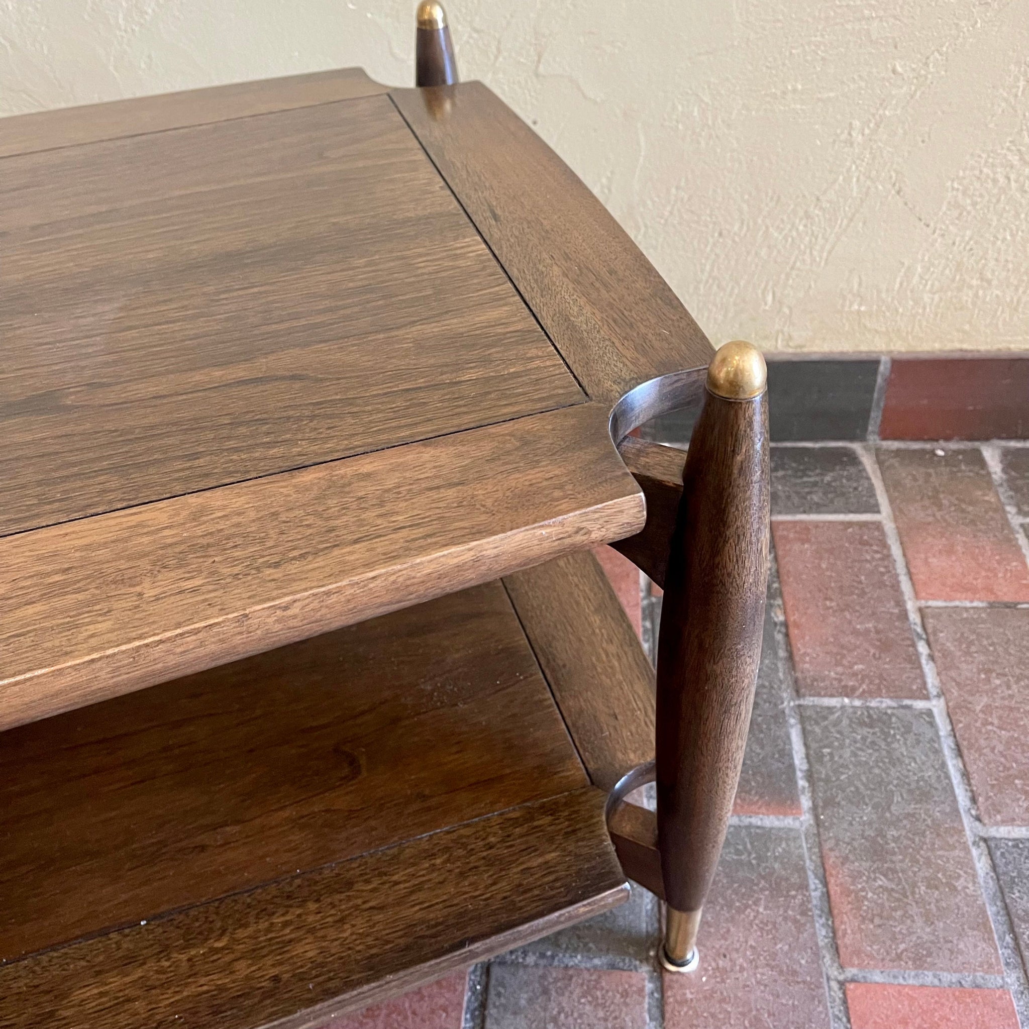 top view Close-up of brass-capped legs on vintage walnut and mahogany coffee table