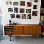 Styled view of Danish teak sideboard with vintage art and pottery