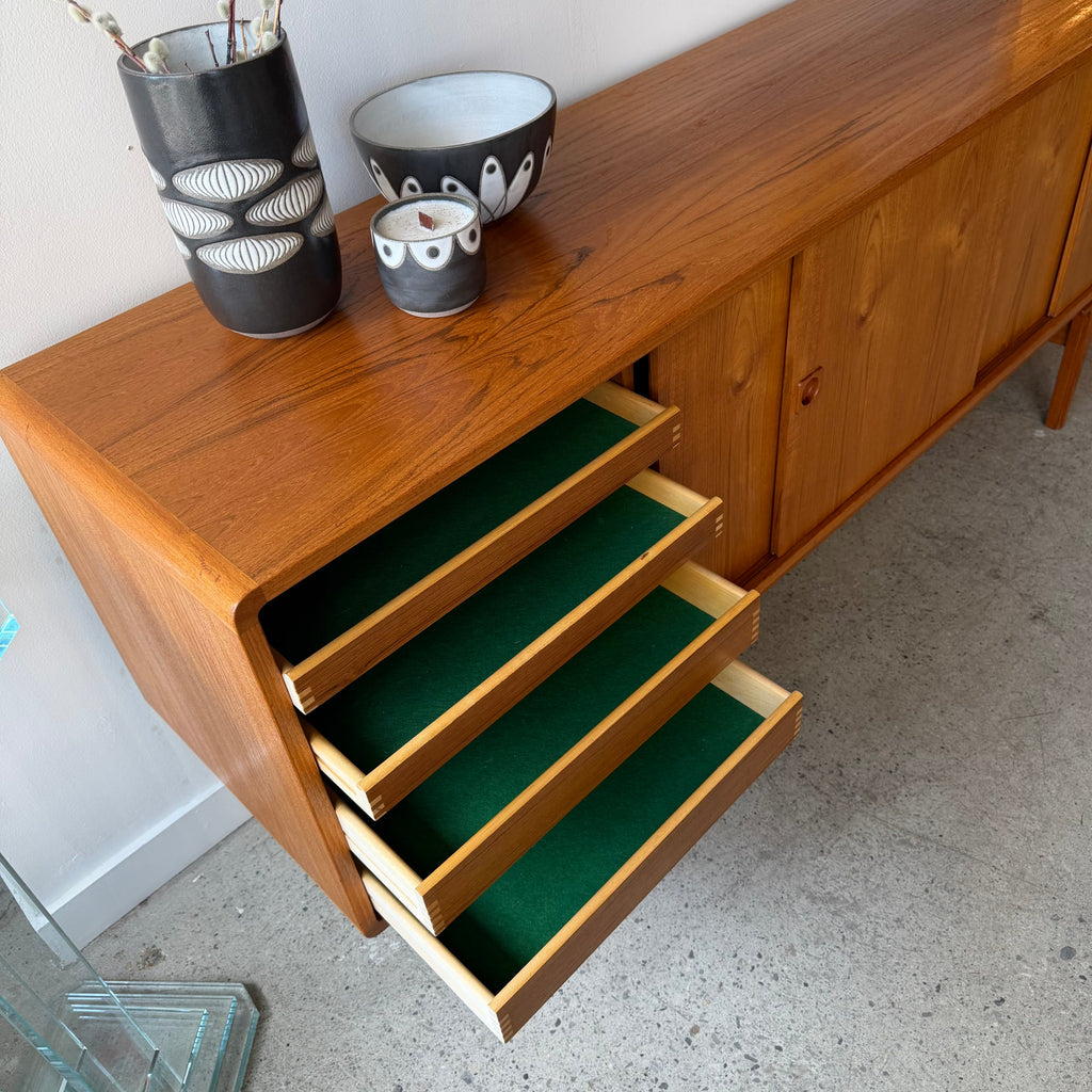 Felt-lined drawers open on mid-century Danish teak sideboard