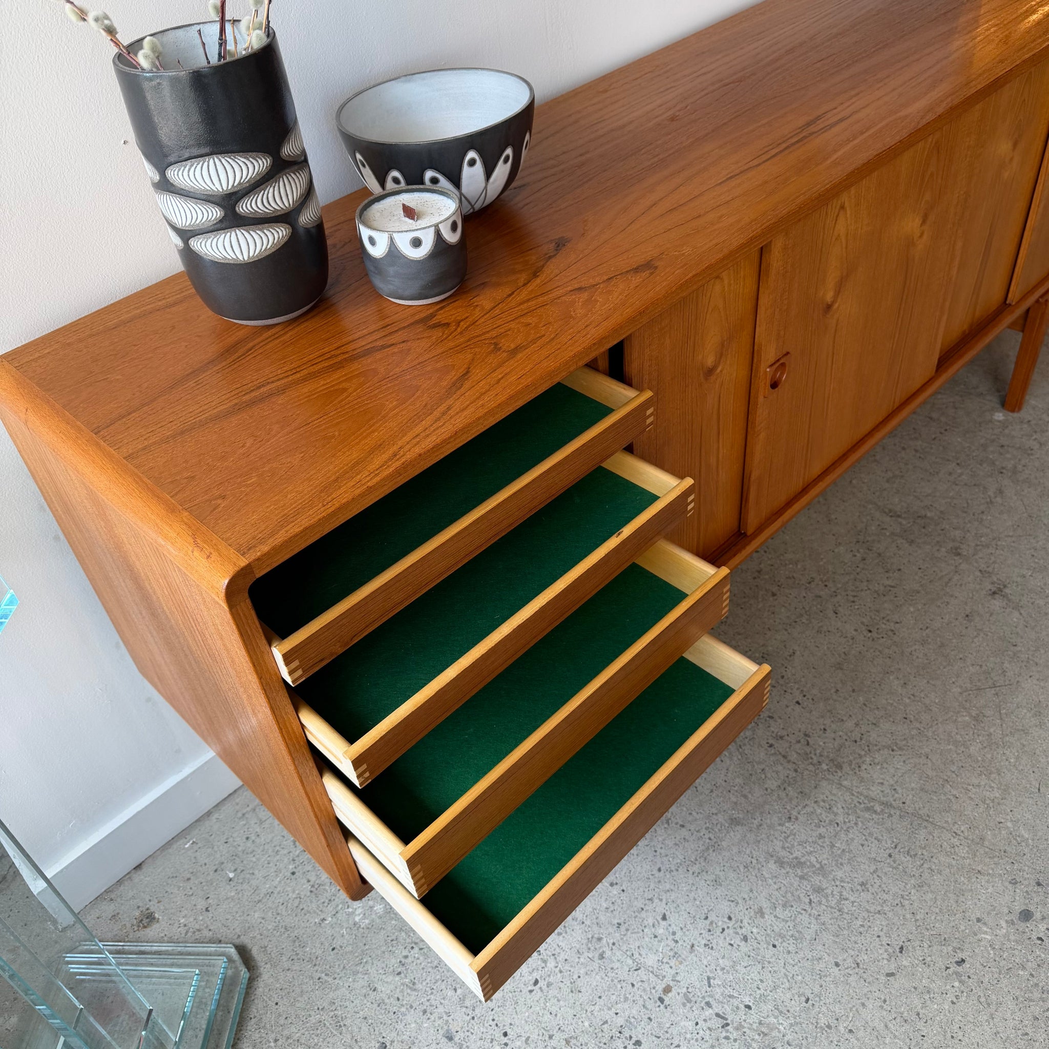Felt-lined drawers open on mid-century Danish teak sideboard