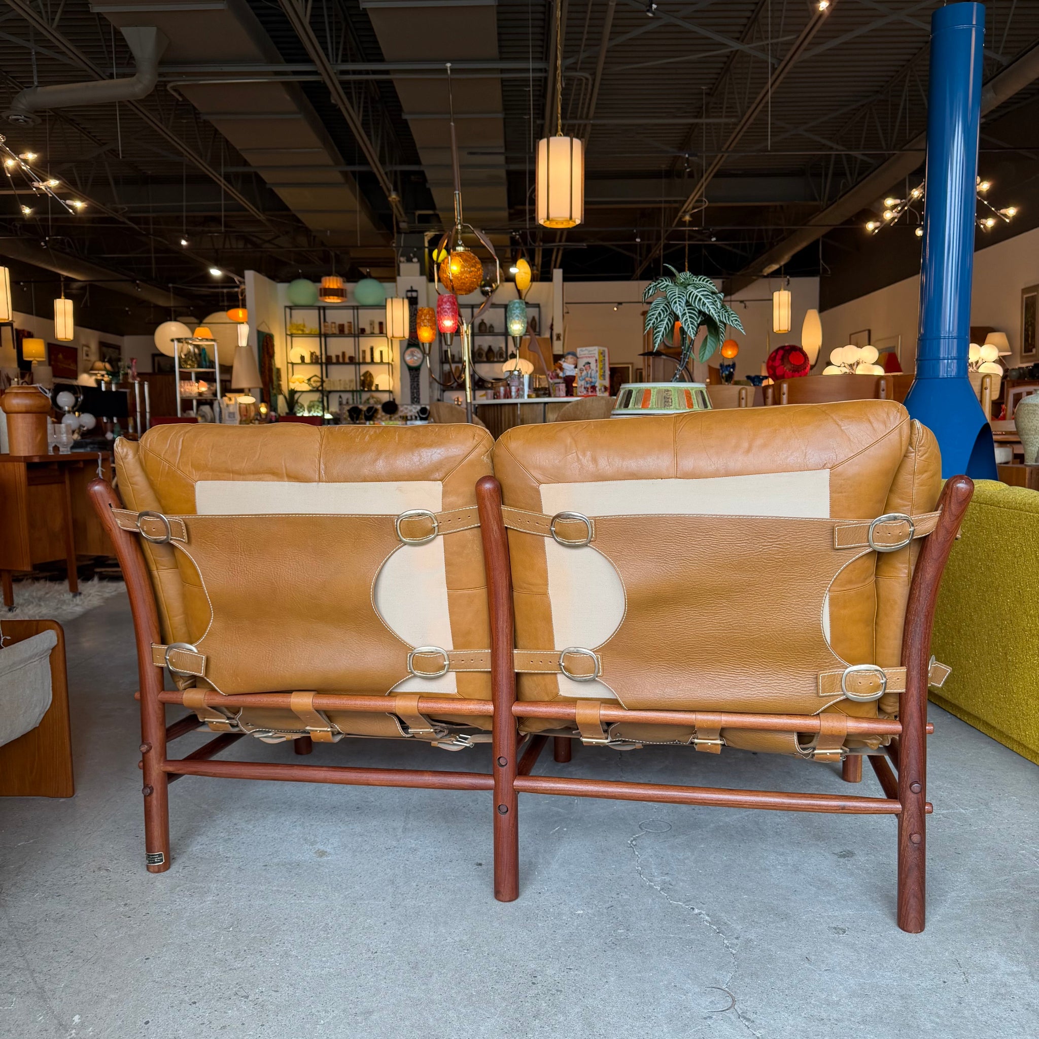 Back of Scanform loveseat showing leather straps and buckles