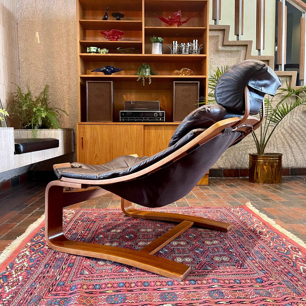 Side view of Kroken lounge chair showing reclined leather seat and sculptural teak frame