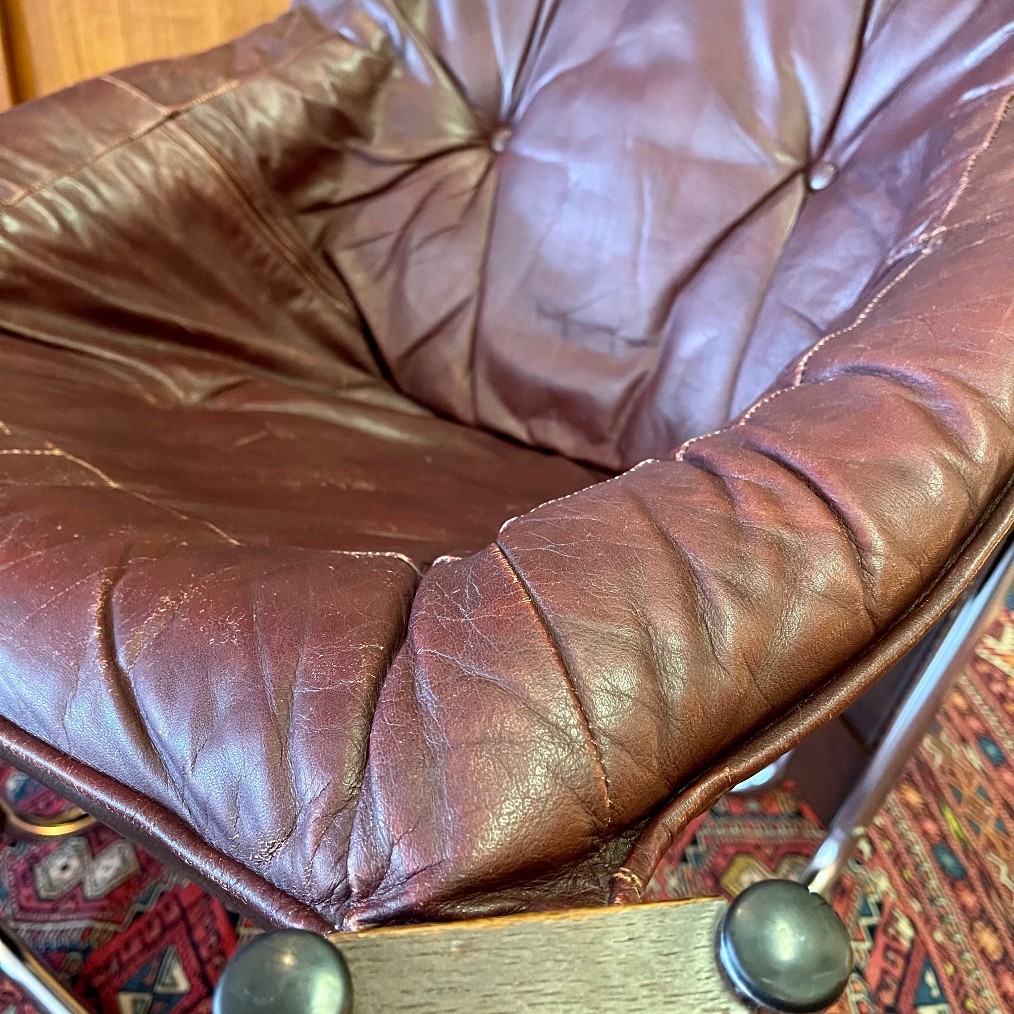Leather seat detail and natural wear on burgundy Sonic lounge chair