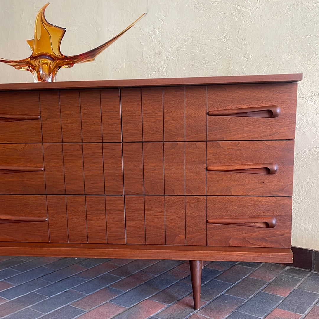 Close-up of Viscol Victoriaville walnut dresser showing sculpted mid-century drawer handles and tapered legs
