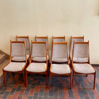 Front view of R. Huber & Co mid-century teak dining chairs