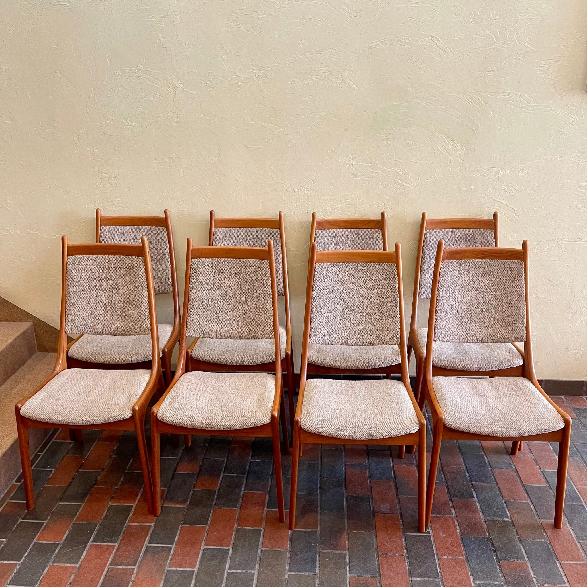 Front view of R. Huber & Co mid-century teak dining chairs